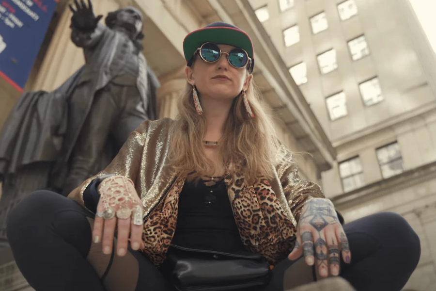 Heather Morgan v videospotu, ki je bil posnet na znani Newyorški ulici Wall Street. Vir slike: Youtube.